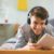 Stock image of a teenage boy smiling and listening to music in his bedroom