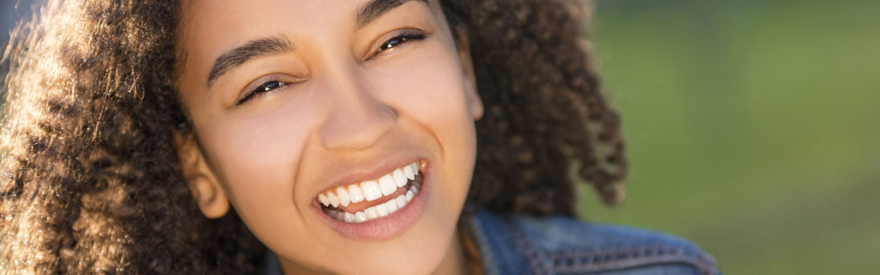 Stock image of a young girl smiling outside